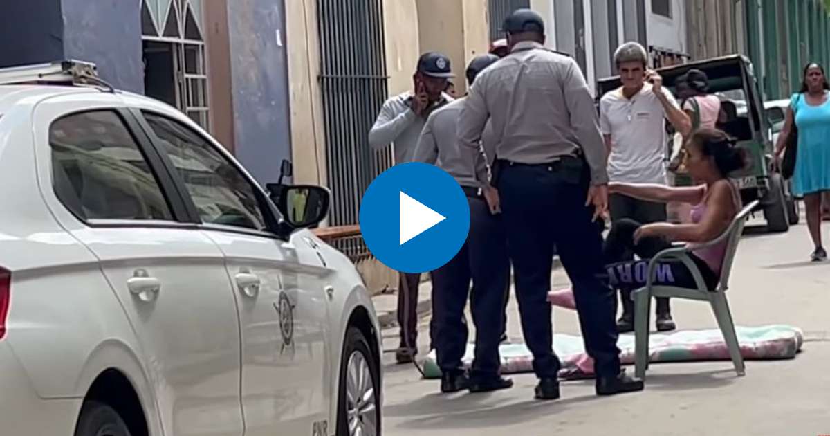 Oficiales de la policía hablan con la mujer para que abandone la protesta © Captura de video de YouTube de CubaNet