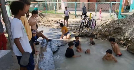Niños en Cuba usan un bache inundado como piscina