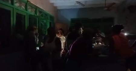 A oscuras y alumbrados por celulares: Así hacen cola para comprar pollo en Cuba