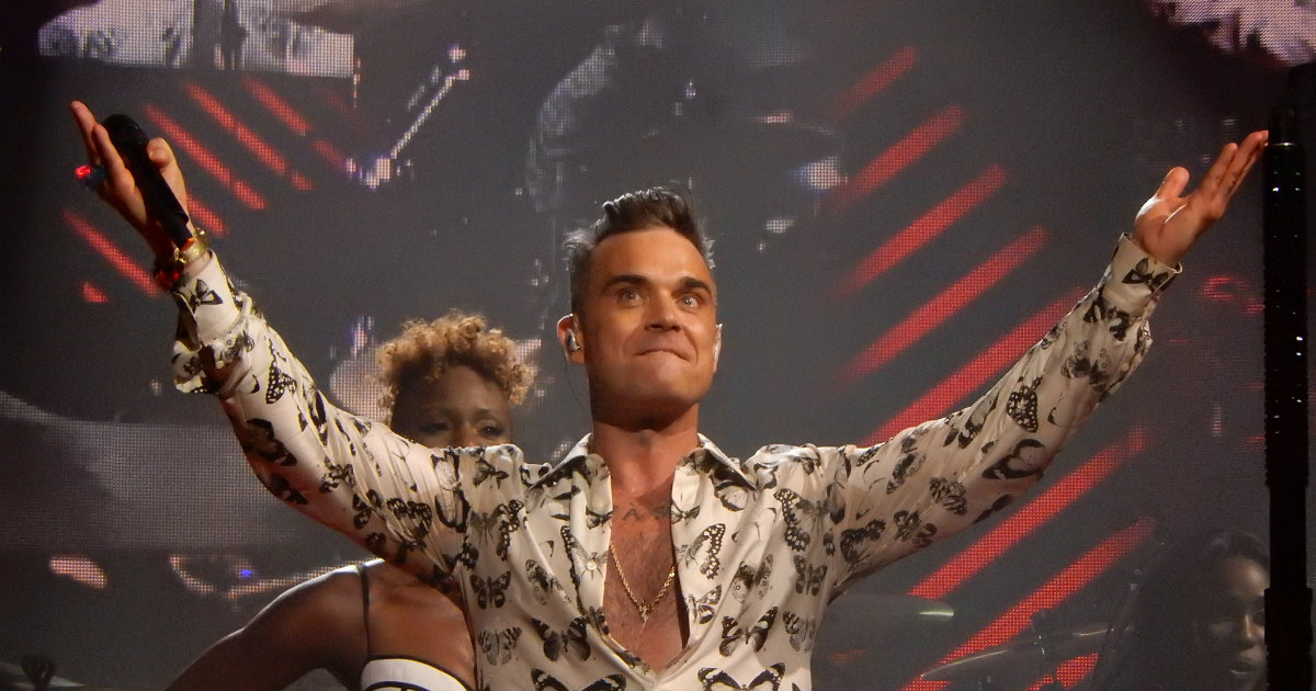 El cantante Robbie Williams levanta los brazos durante un concierto © Flickr / Drew de F Fawkes