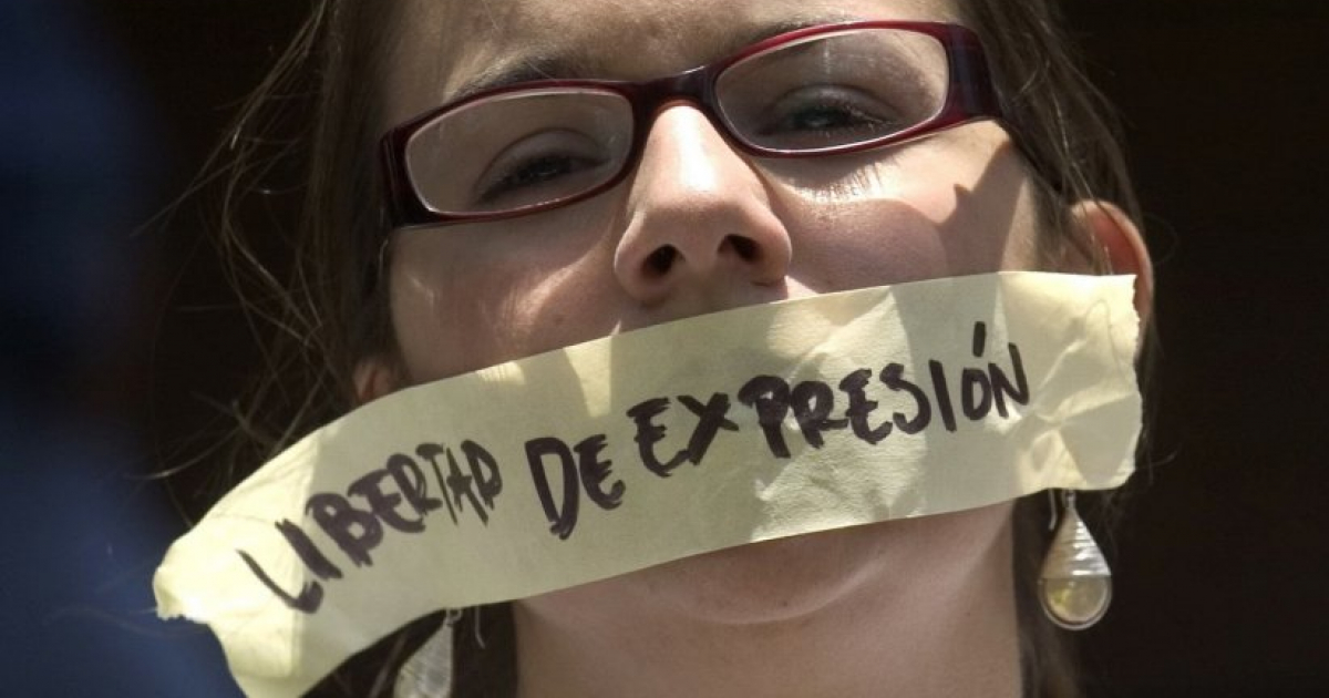 Periodista con la boca tapado con un papel que denuncia la falta de libertad de expresión © Sociedad Interamericana de Prensa