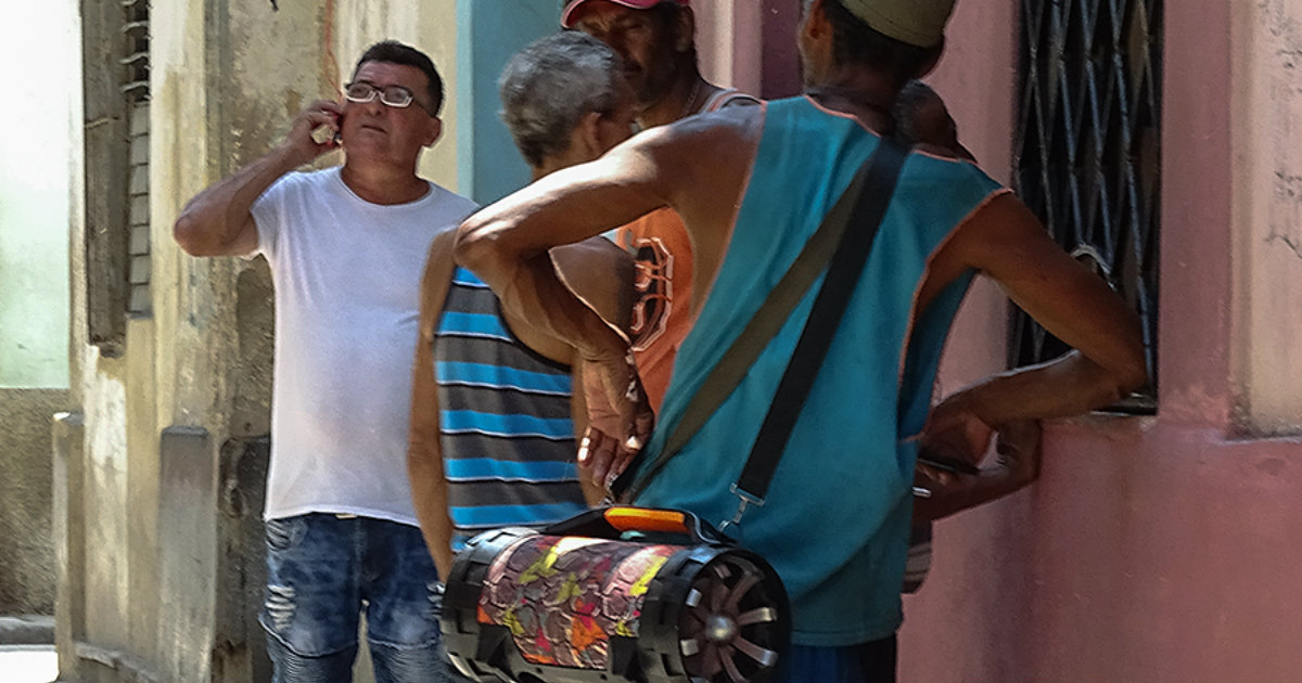 Un hombre, con una bocina al hombro, en una calle de La Habana. © CiberCuba.