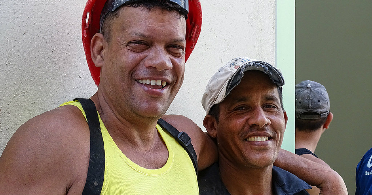 Dos cubanos sonríen mientras trabajan en la construcción en la Habana Vieja © CiberCuba