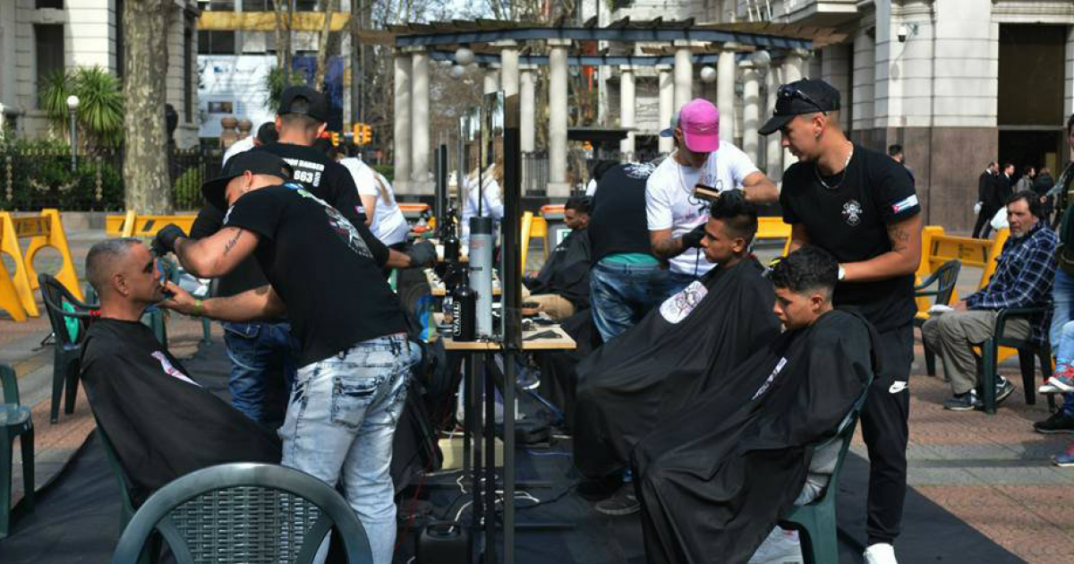 Barberos cubanos trabajando en plena calle en Uruguay © Facebook / Revolution barber