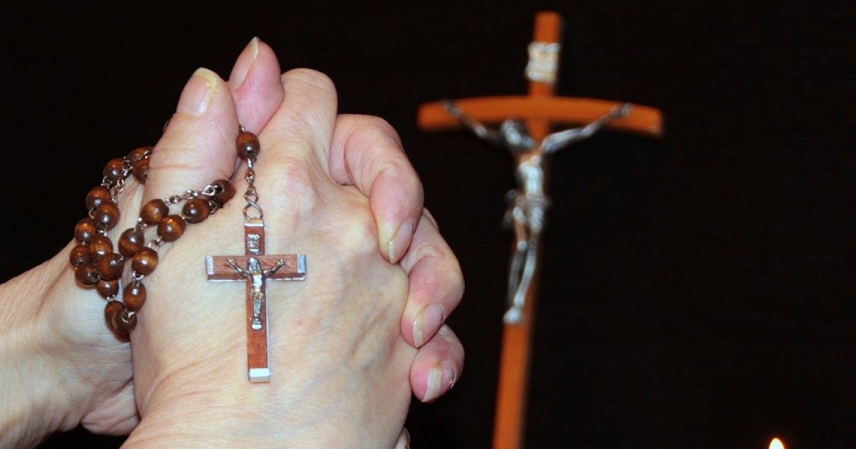 Persona ora con un rosario. © Pixabay