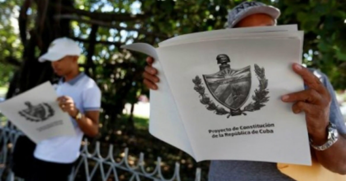 Dos cubanos leen el proyecto de reforma de la Constitución cubana. © Cubasi.