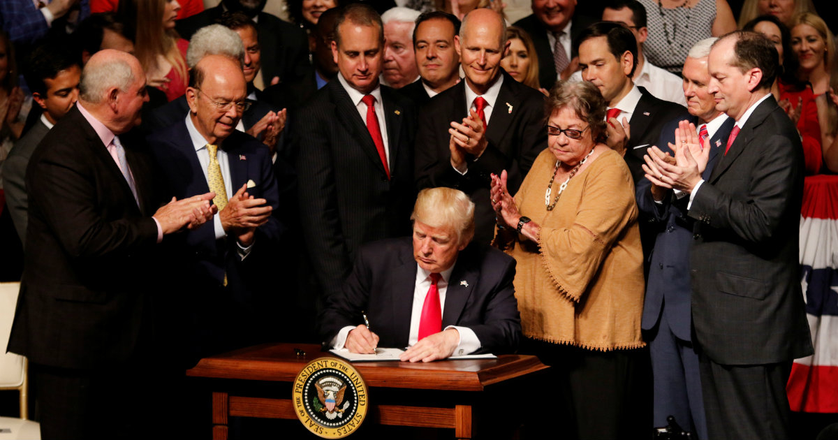Trump firma un documento tras anunciar su política hacia Cuba en La Pequeña Habana en Miami © REUTERS/Joe Skipper