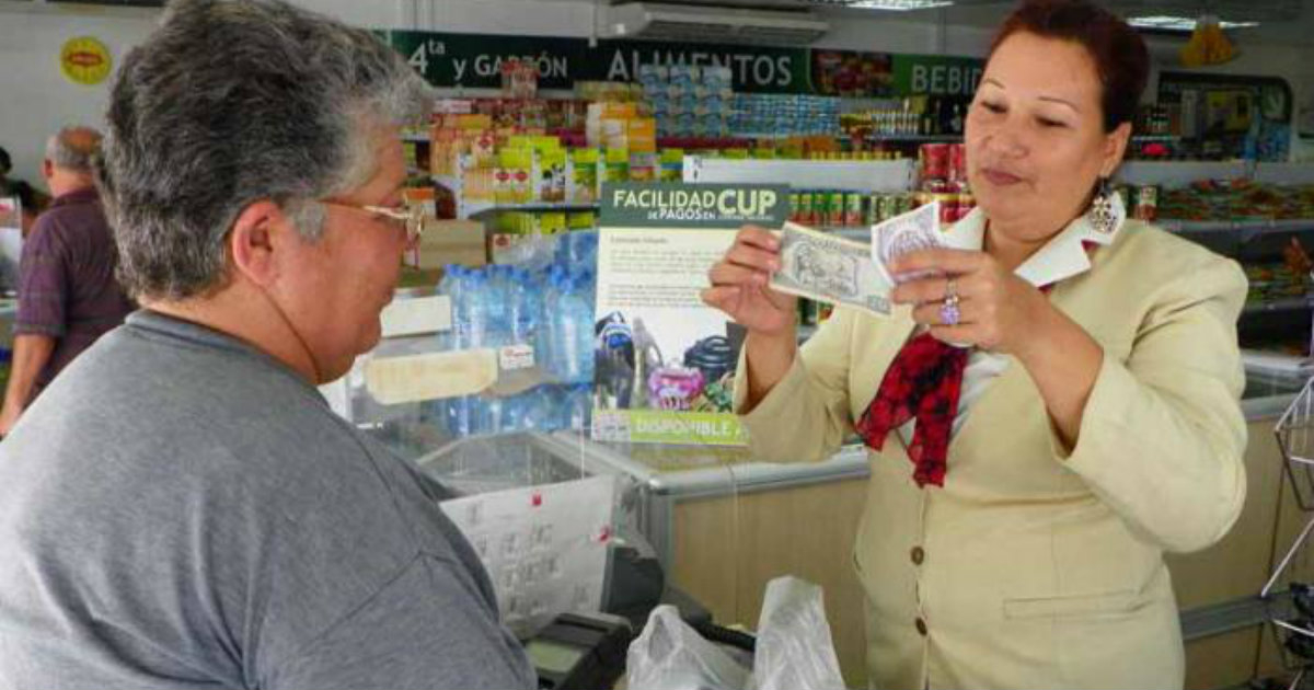 Una empleada comprueba los billetes con que le paga una usuaria. © Granma