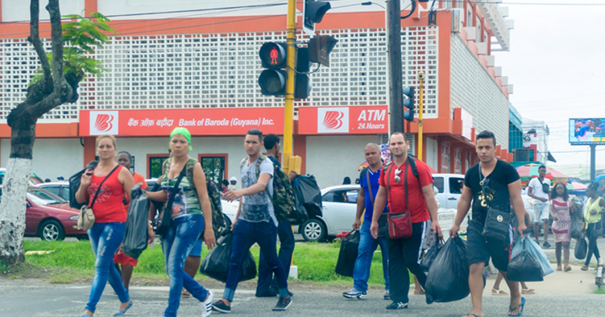 Migrantes cubanos, que llevan bolsas, pasean en Guyana © Guyana Chronicle