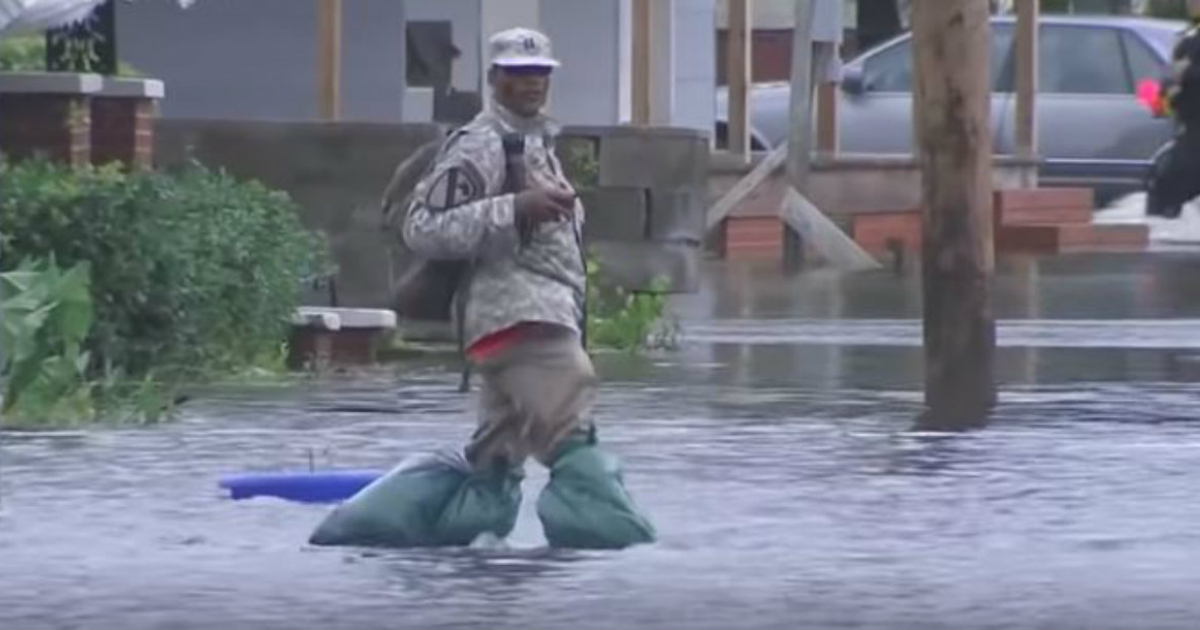 Un hombre cruza una calle inundada © YouTube/screenshot