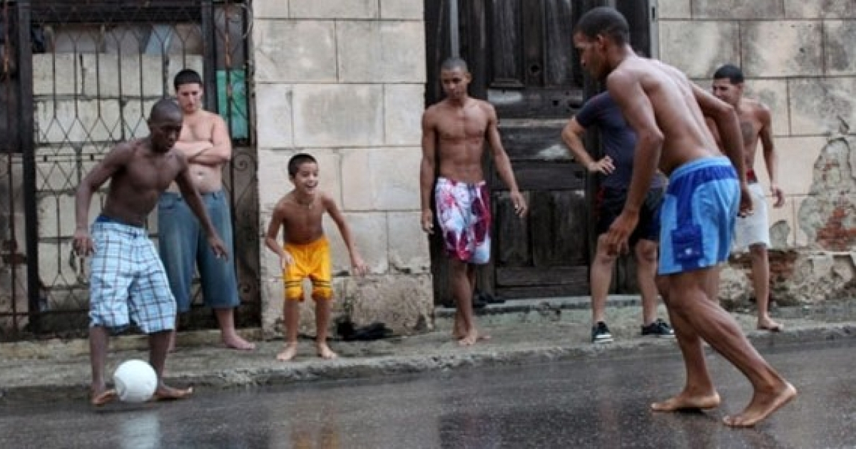 Jóvenes cubanos juegan fútbol en la calle. © Cubadebate