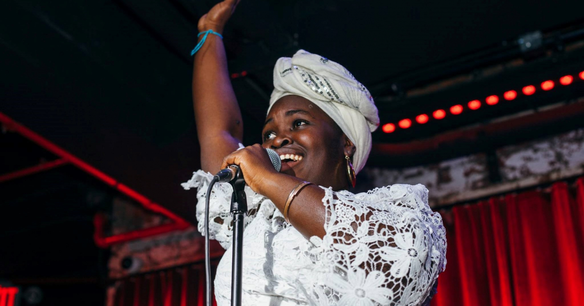 La artista Daymé Arocena levanta su brazo en pleno concierto © Facebook / Daymé Arocena