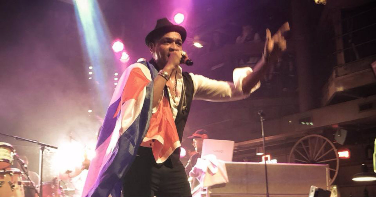 El cantante cubano Descemer Bueno sostiene la bandera de Cuba en pleno concierto © Facebook / Descemer Bueno