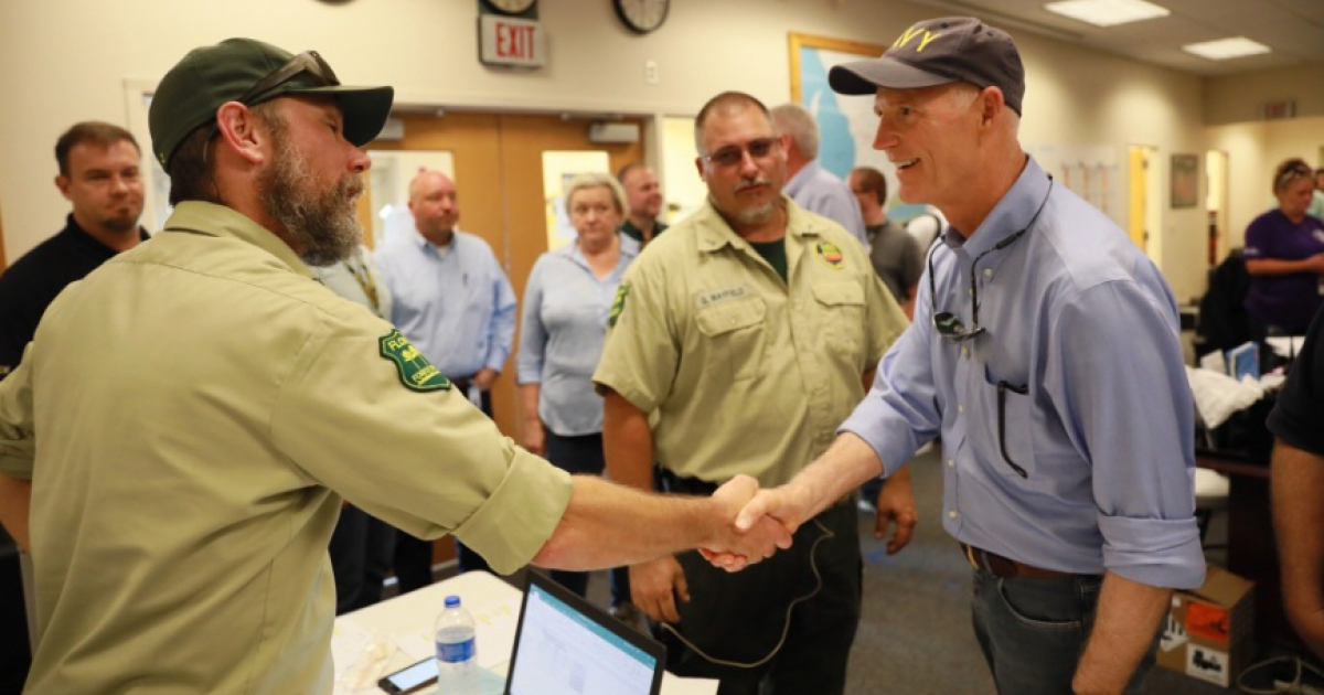 El gobernador de Florida, Rick Scott, estrecha la mano a un oficial © Twitter / @FLGovScott