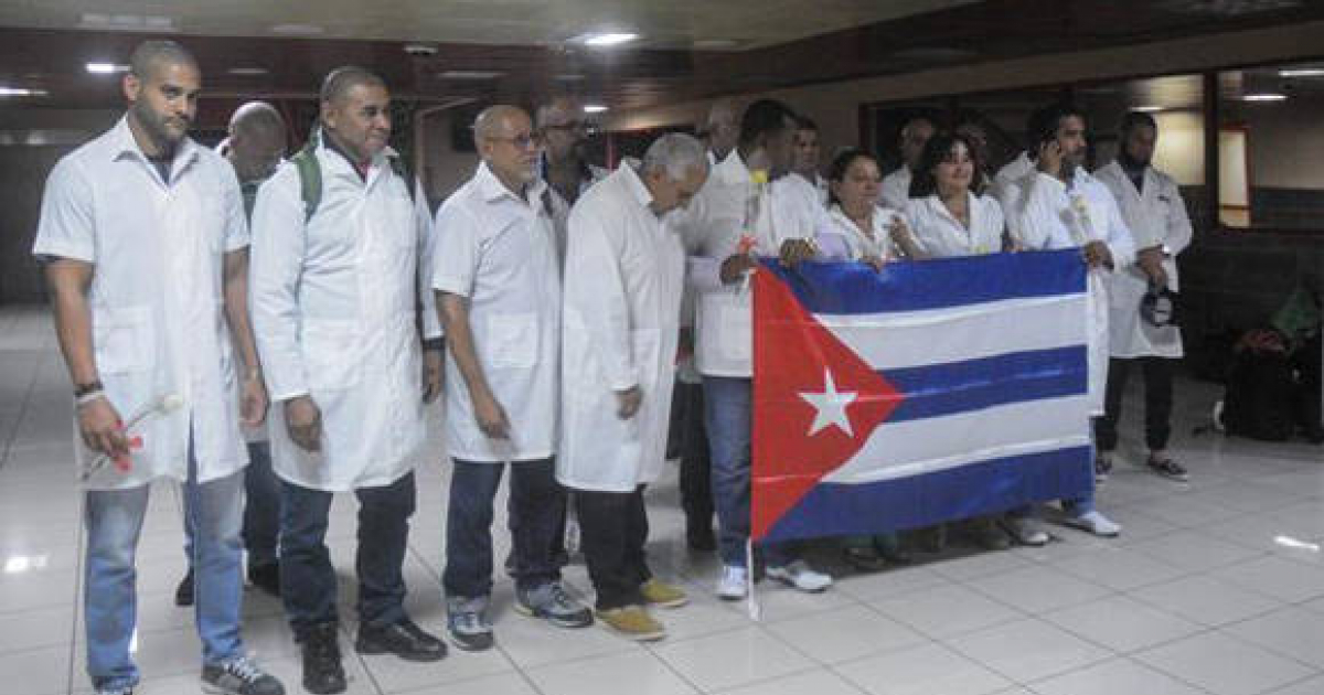 Médicos cubanos posan con la bandera de la Isla © ACN / Oriol de la Cruz