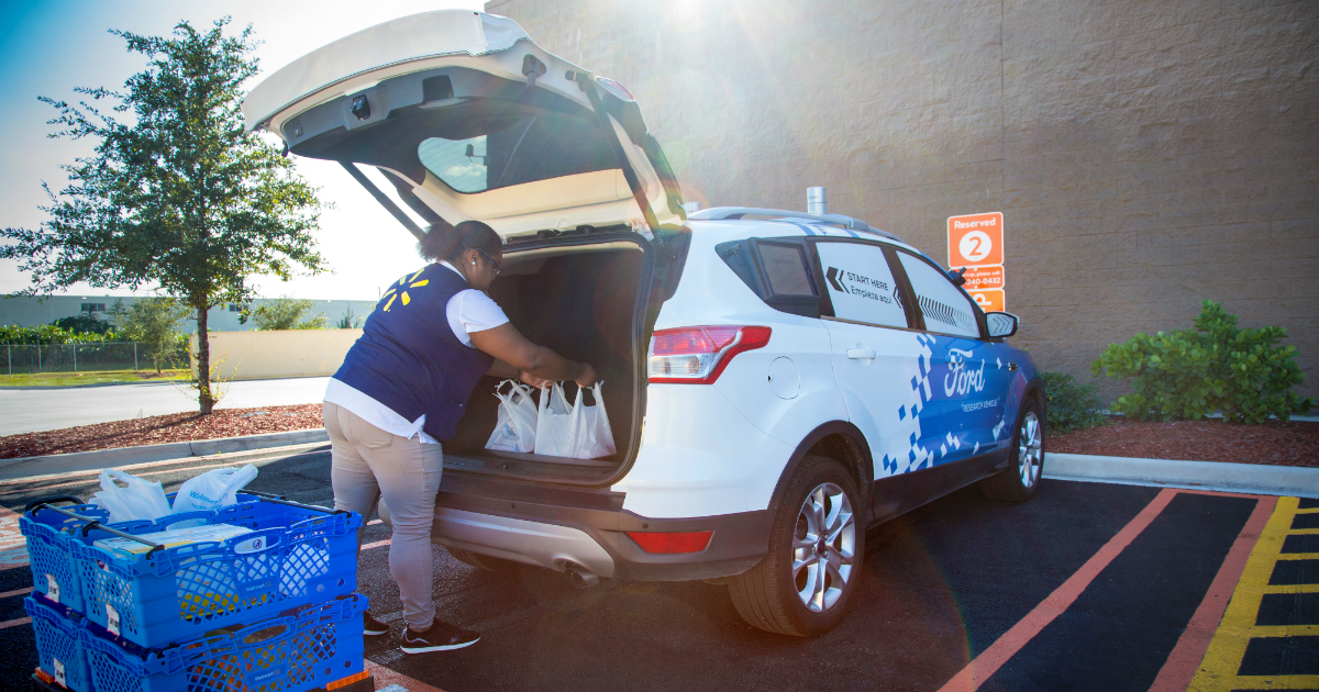 Una trabajadora de Walmart pone la compra en un coche autónomo de Ford. © Ford Media Center