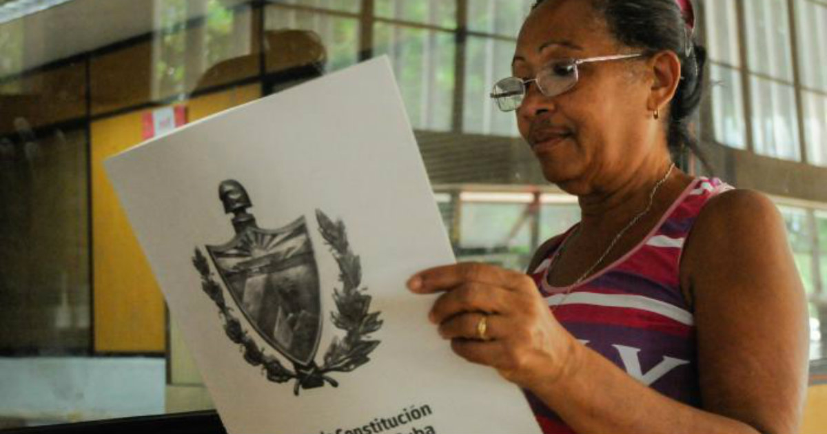 Una cubana lee el proyecto de reforma de la Constitución. © Granma