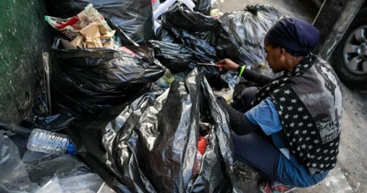Una mujer en Miami rebusca en la basura © EFE