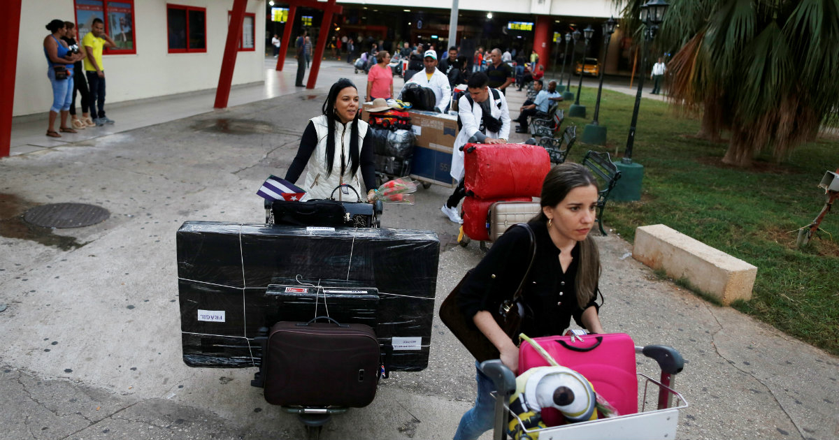 Médicos cubanos portan televisores a su salida del Aeropuerto José Martí © REUTERS / Fernando Medina
