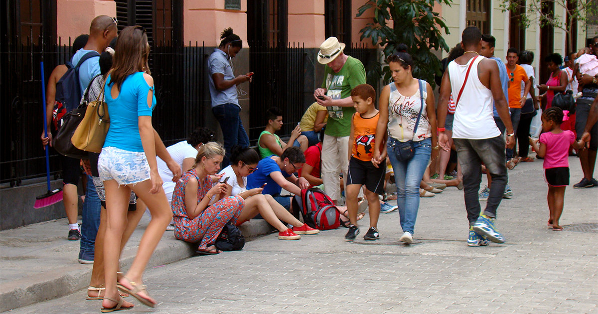 Cubanos y extranjeros conectados a wifi en la calle Obispo de La Habana. © CiberCuba.