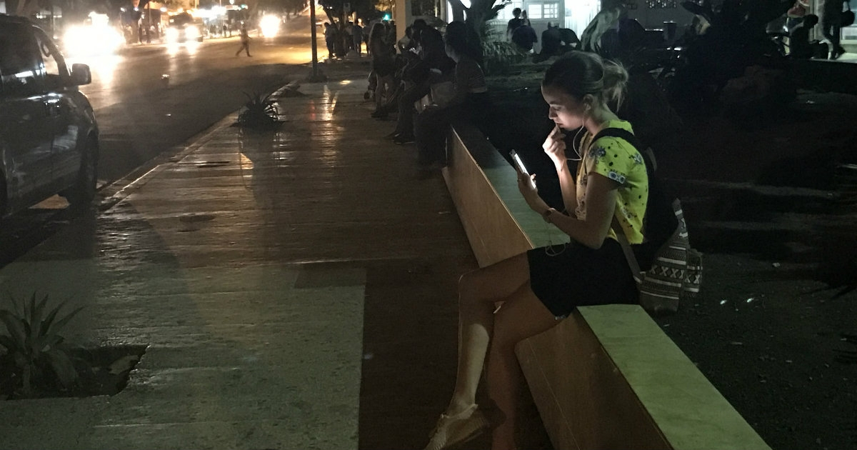 Joven mira su celular en Cuba © CiberCuba