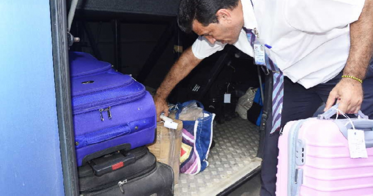 Maletero guarda el equipaje en un ómnibus nacional. © Escambray/ Vicente Brito
