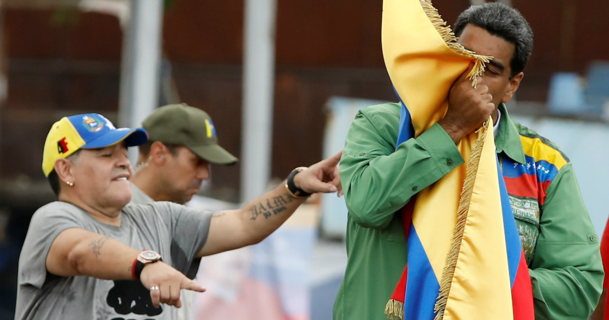 Maradona baila ante Maduro, que besa la bandera de Venezuela © Reuters / Carlos Garcia Rawlins