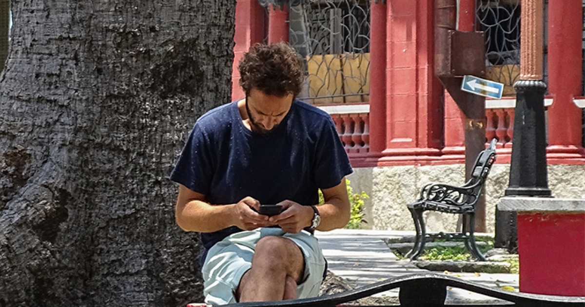Joven cubano consulta internet en un parque © CiberCuba