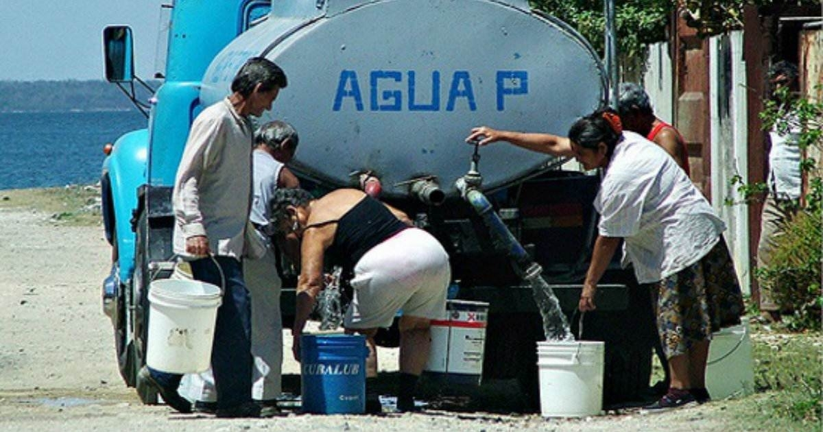 Cubanos cogen agua de una pipa. © CiberCuba