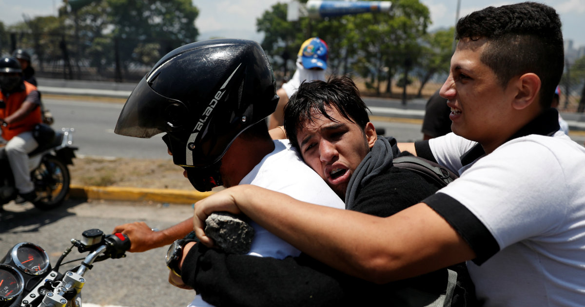 Un opositor venezolano herido cerca de La Carlota es trasladado por compañeros © REUTERS/Carlos Garcia Rawlins