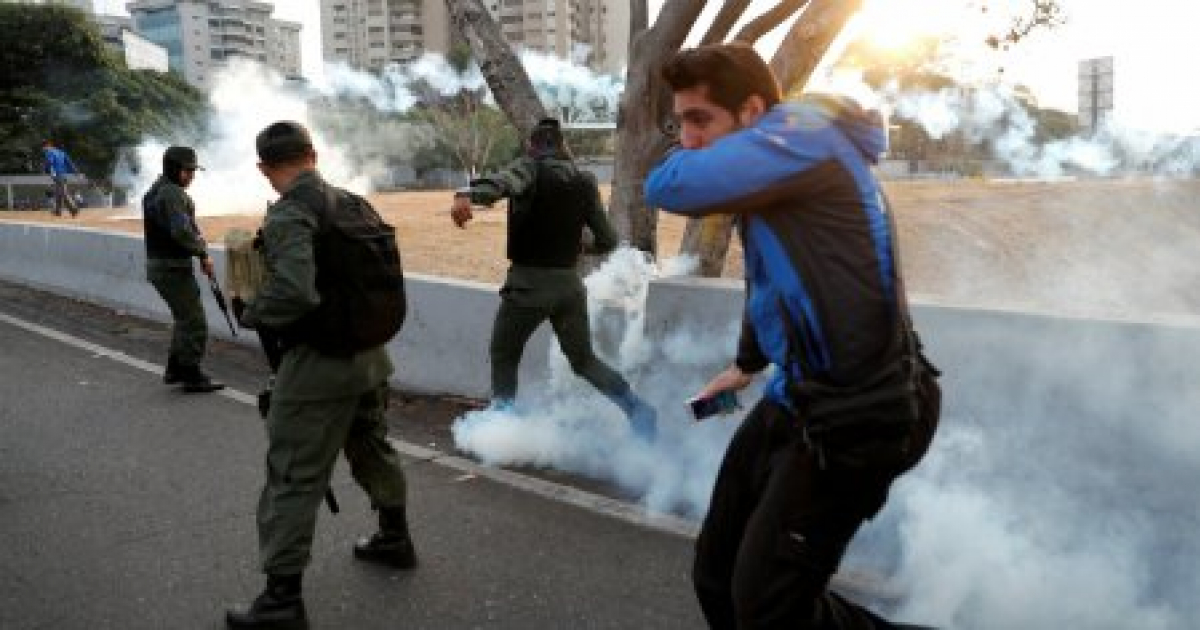 Miembros militares reaccionan a los gases lacrimógenos, cerca de la base aérea "La Carlota" © Reuters / Carlos Garcia Rawlins