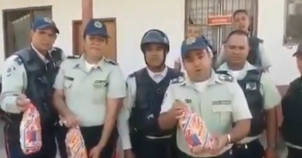 Policías venezolanos con una bolsa de pollo en la mano © Captura de Twitter/Freddyur