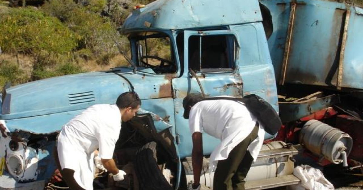 Dos personas inspección un camión destrozado que colisionó en Guantánamo © Venceremos