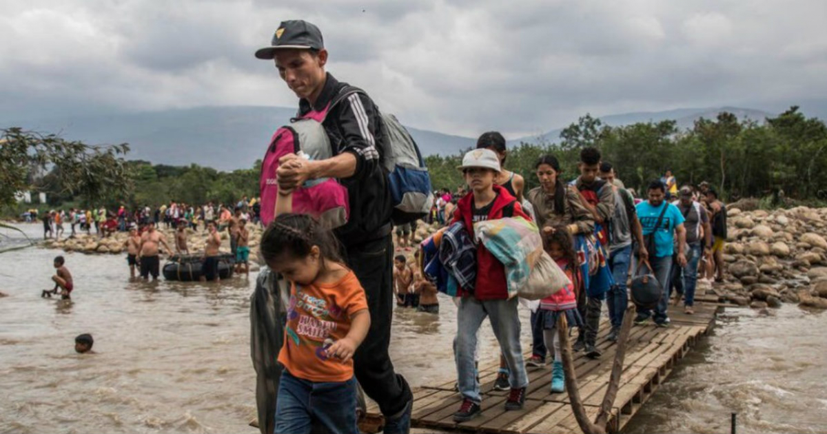 Migrantes venezolanos cruzan un el río © Twitter / @ACNURamericas