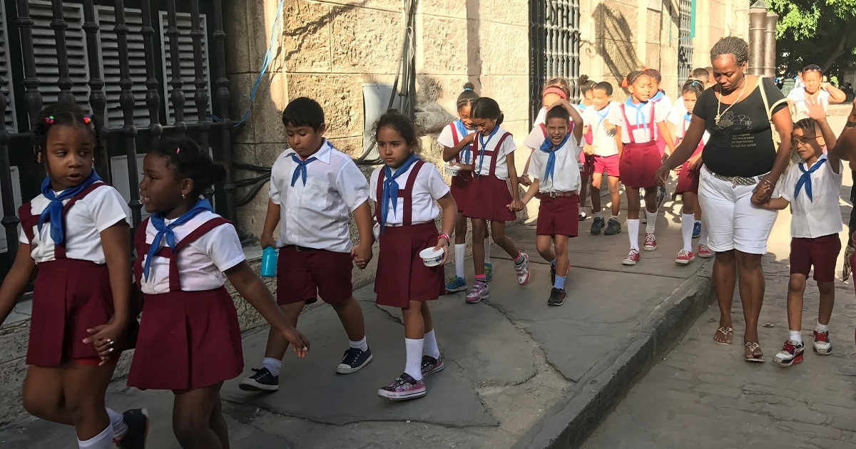 Maestra con sus alumnos caminan por la calle © CiberCuba