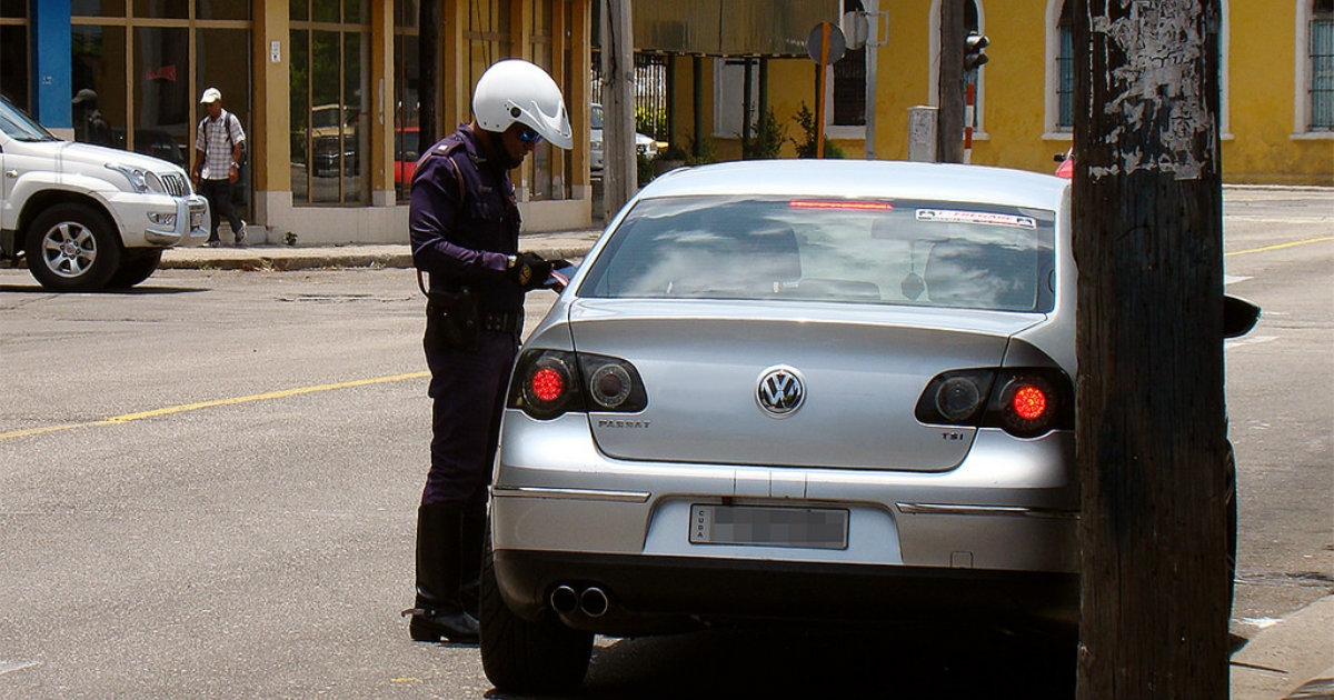 Un policía cubano junto a un auto © CiberCuba