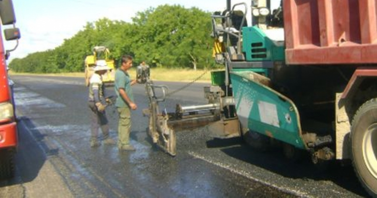 Trabajadores rellenan de asfalto una carretera en Cuba © Escambray