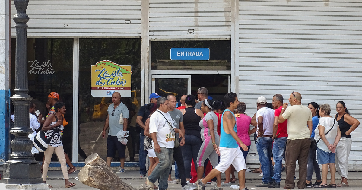 Cubanos esperan a la entrada de un mercado © CiberCuba