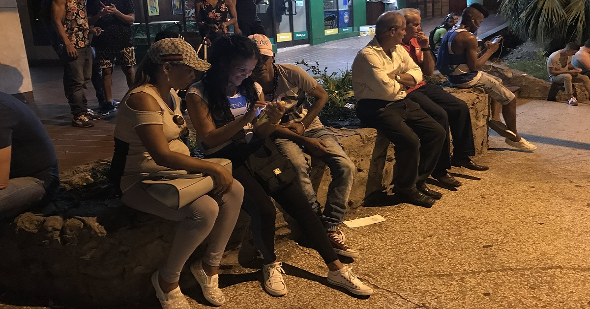Cubanos conectados en zona Wi-Fi de La Rampa en Vedado, La Habana. © CiberCuba
