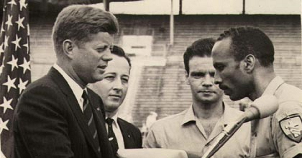 El presidente John F. Kennedy recibe la bandera de la Brigada de Asalto 2506 de manos de Erneido Oliva, en 1962 © AARP.org