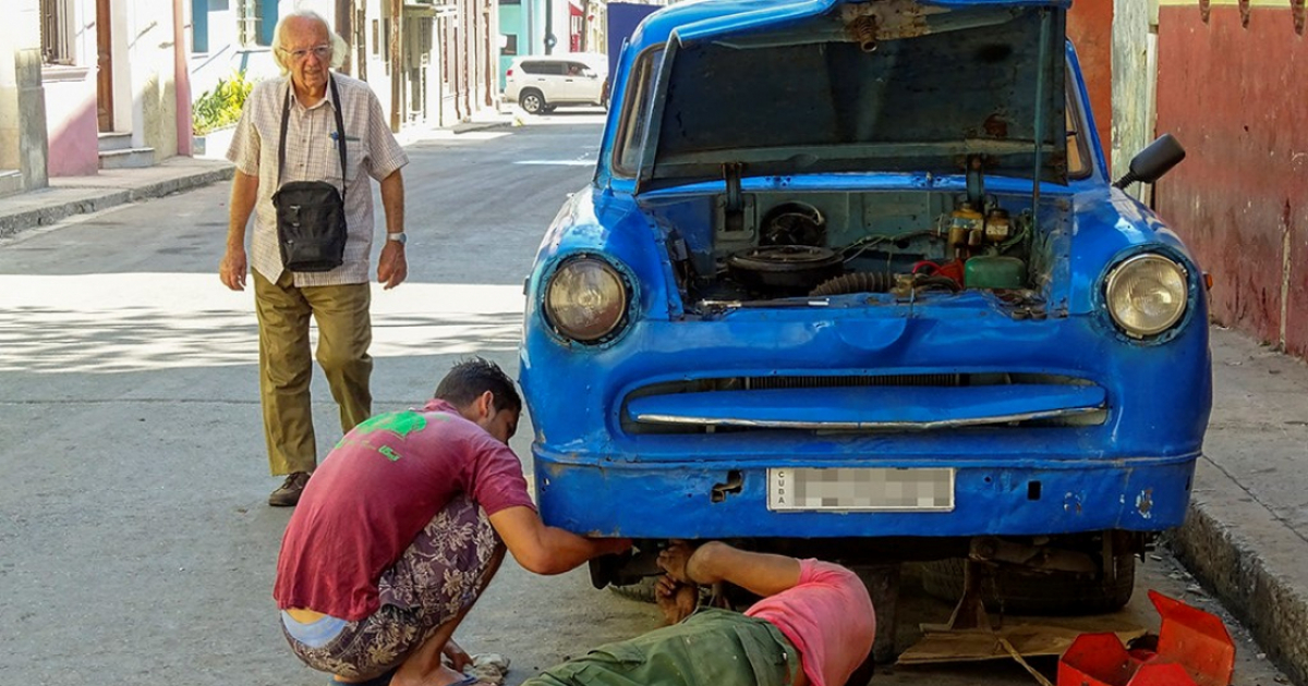 Cubanos arreglando un carro © CiberCuba