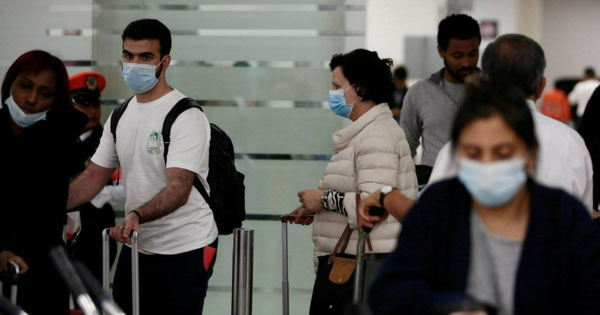 Viajeros protegiéndose del coronavirus © Reuters