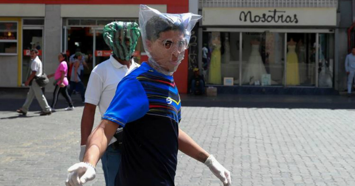 Dos ciudadanos se protegen con bolsas de plástico en Caracas © REUTERS/Carlos Jasso