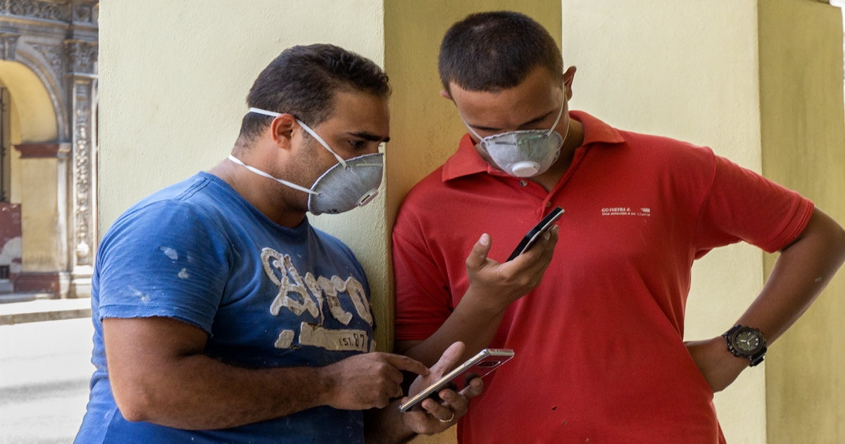 Cubanos con mascarillas y celulares. (imagen de referencia) © CiberCuba