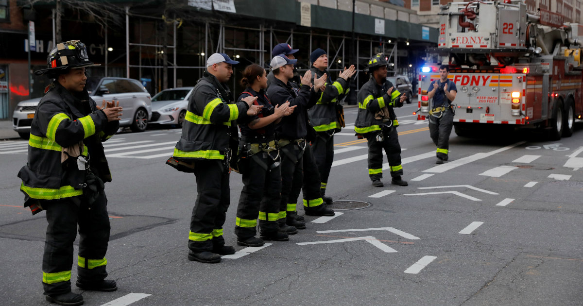 Miembros de los equipos de bomberos Ladder 22 y Engine 76, de Nueva York, aplauden a los trabajadores de salud y médicos del hospital Mount Sinai Morningside a las 7:00 PM, en Manhattan, en Nueva York, el 2 de abril © REUTERS / Andrew Kelly