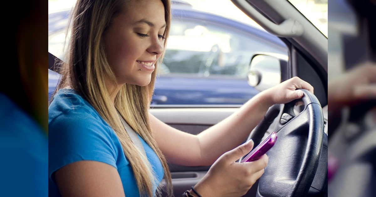 Chica texteando mientras maneja © Freestockphotos.biz