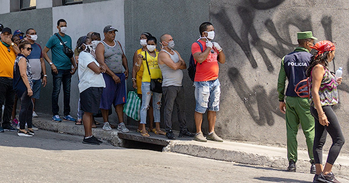 Colas en Cuba con la presencia de un agente de policía © CiberCuba