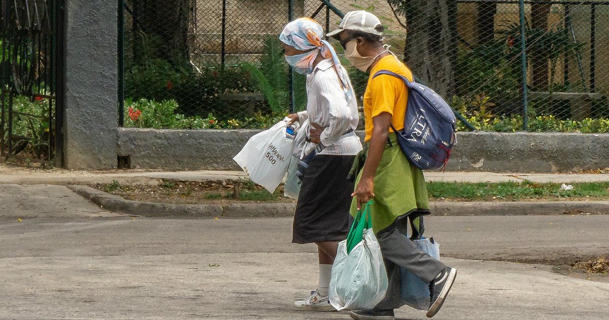Personas en Cuba caminan con nasobucos por la calle © CiberCuba
