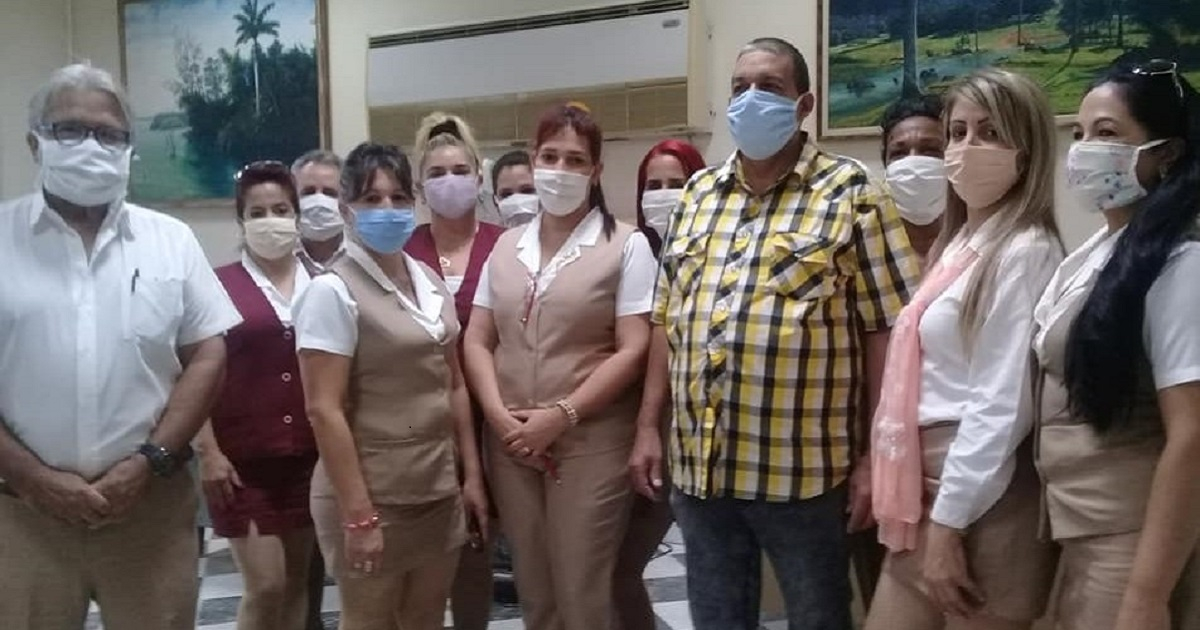 Trabajadores bancarios en Guane posan para una foto junto al donante, vestido con camisa a cuadros. © Facebook / Asamblea Municipal Guanes