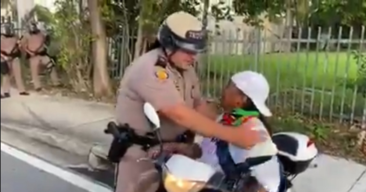Policía de Miami abraza a manifestante © Captura de video / Local 10
